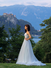Lade das Bild in den Galerie-Viewer, Das Brautkleid A-Linie mit abnehmbaren Ärmeln – Romantisches Tüll-Hochzeitskleid nach Maß, präsentiert in einer eleganten Umgebung.