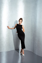 Lade das Bild in den Galerie-Viewer, Ein wunderschönes Cocktailkleid schwarz von Anna Kaval, ideal für festliche Anlässe. Das schlichte Design betont die Silhouette und ist perfekt für Damenkleider. Das Model präsentiert den eleganten Look in einem kunstvollen Setting.