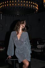 Lade das Bild in den Galerie-Viewer, Lächelnde Frau in einem schickes Kleid für festliche Events von Anna Kaval, ideal für Damenkleider, genießt einen glamourösen Moment in einem modernen Ambiente.