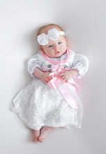 Lade das Bild in den Galerie-Viewer, Ein süßes Baby in einem Babydirndl, Taufdirndl, Taufkleid aus Seide und Spitze von Anna Kaval, mit rosa Satinband und einer passenden Kopfband, auf einem hellen Hintergrund. Kinderdirndl, Taufdirndl.