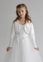 Lade das Bild in den Galerie-Viewer, Ein Mädchen in einem eleganten weißen Bolero aus Satin mit Perlen von Anna Kaval, perfekt für besondere Anlässe. Dieser Bolero aus Satin eignet sich hervorragend als Accessoire und Oberteil zu einem Taufkleid oder Festkleid.