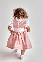 Lade das Bild in den Galerie-Viewer, Das kleine Mädchen im Babydirndl/Taufdirndl/Taufkleid Traum aus Seide von Anna Kaval dreht sich um und zeigt den Rückenausschnitt des Kleides.