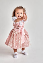 Lade das Bild in den Galerie-Viewer, Ein kleines Mädchen posiert im Taufdirndl Traum aus Seide von Anna Kaval, kombiniert mit einer schönen Schürze.