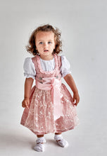 Lade das Bild in den Galerie-Viewer, Ein süßes Kind steht stolz in dem Taufdirndl Traum aus Seide von Anna Kaval, mit elegantem Design und festlicher Bluse.
