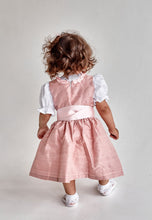 Lade das Bild in den Galerie-Viewer, Ein weiteres Bild vom Rücken eines kleinen Mädchens in dem Babydirndl/Taufdirndl/Taufkleid Traum aus Seide von Anna Kaval, während sie sich umdreht.