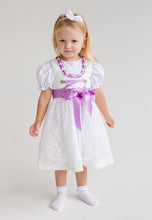Lade das Bild in den Galerie-Viewer, Das süße Mädchen trägt ein Flieder Taufdirndl von Anna Kaval mit eleganten Puffärmeln und einer hübschen Satin-Schleife, perfekt für besondere Anlässe.