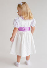 Lade das Bild in den Galerie-Viewer, Rückansicht eines kleinen Mädchens im Babydirndl von Anna Kaval in Flieder. Das Taufdirndl zeigt eine elegante Silhouette mit einer hübschen Schürze.