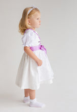 Lade das Bild in den Galerie-Viewer, Seitenansicht eines süßen Mädchens in einem Flieder Taufdirndl von Anna Kaval. Mit hohen Puffärmeln und feiner Schnürung strahlt es Eleganz und Stil aus.