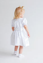 Lade das Bild in den Galerie-Viewer, Bezauberndes Baby Trachtenkleid zur Taufe von Anna Kaval, ein kleines Mädchen von hinten in einem klassischen weißen Kleid mit elegantem Schnitt.